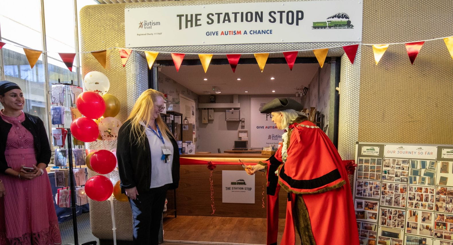 Mayor cutting a red ribbon to open a kiosk called The Station Stop
