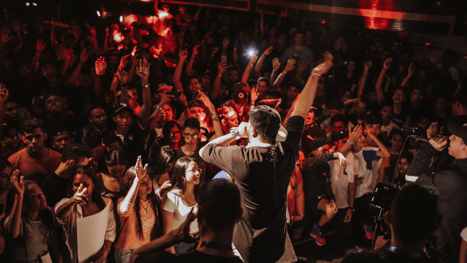 Image of a comedian on a stage performing in front of a large crowd