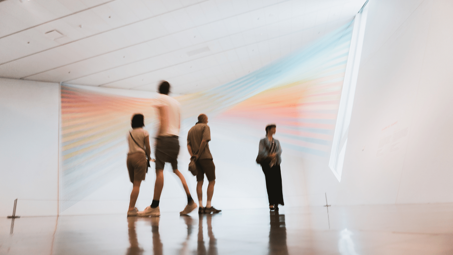 Image of people visiting a museum, looking at paintings