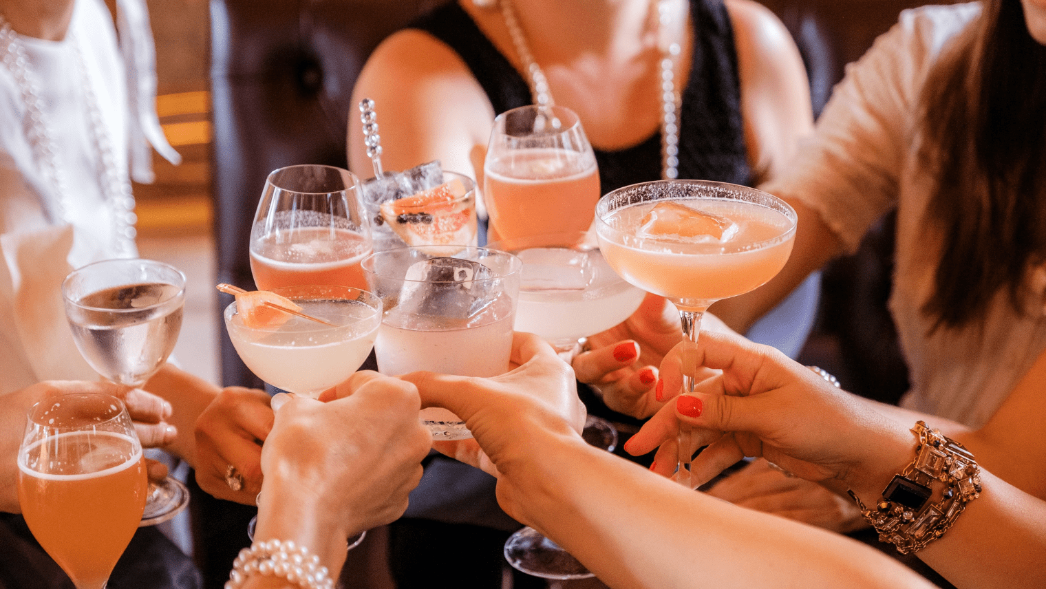A group of people doing a cheers with beverages
